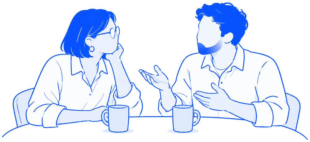 Two colleagues talking over coffee at a table